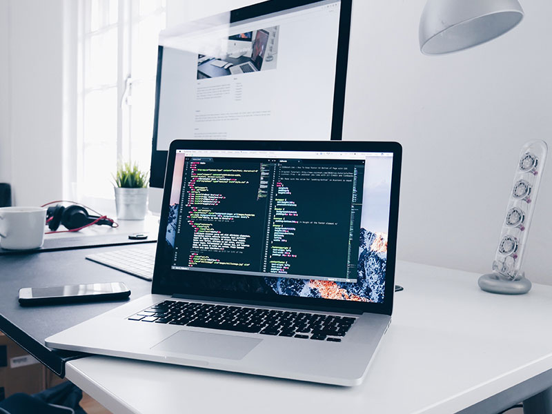 Laptop am Schreibtisch mit geöffnetem Testscript auf dem Bildschirm.