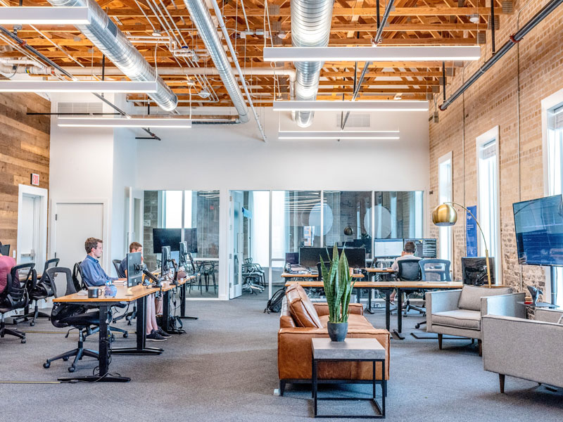 Arbeitende Menschen in modernem Großraumbüro.